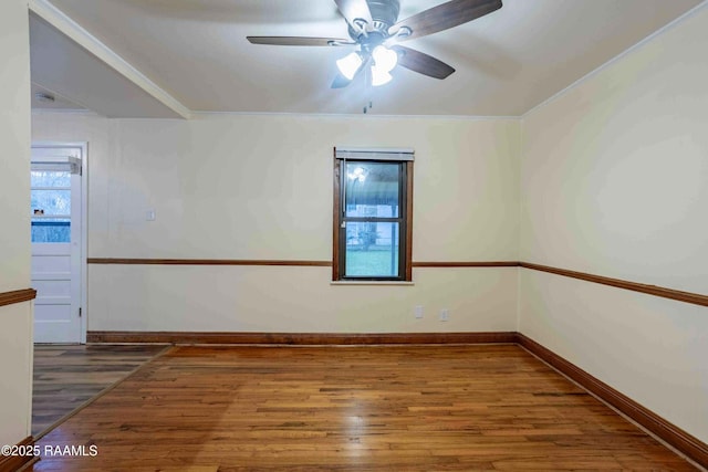 empty room featuring dark hardwood / wood-style flooring, ornamental molding, and ceiling fan