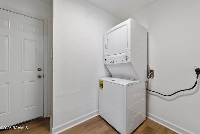 washroom with stacked washer / dryer and hardwood / wood-style floors