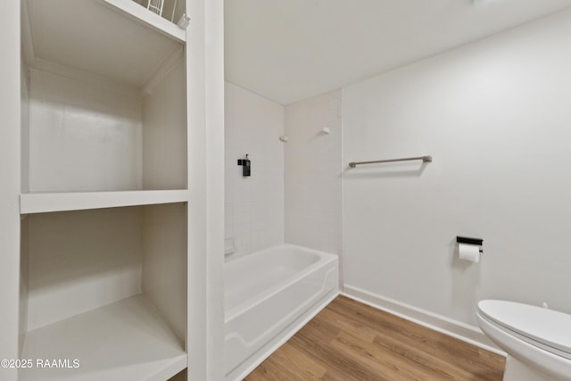 bathroom with shower / washtub combination, toilet, and hardwood / wood-style floors