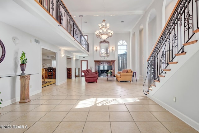 entrance foyer with light tile patterned floors, a towering ceiling, and ornamental molding