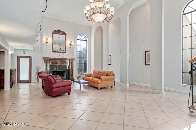 living room with crown molding, a chandelier, light tile patterned floors, and a high end fireplace