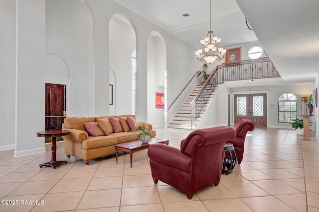 living room featuring a high ceiling, crown molding, light tile patterned floors, and french doors