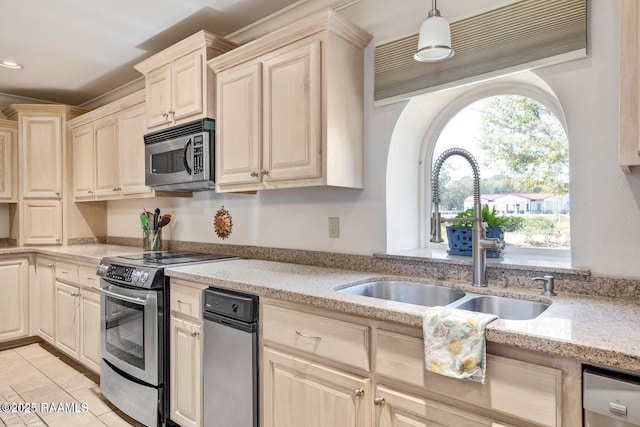 kitchen featuring sink, light stone counters, decorative light fixtures, light tile patterned floors, and stainless steel appliances