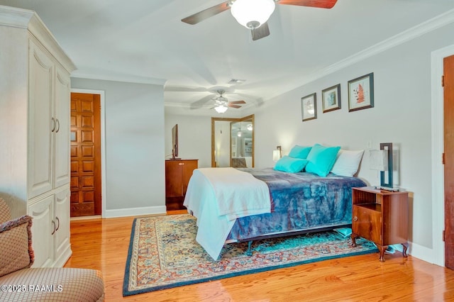 bedroom with ornamental molding, ceiling fan, and light hardwood / wood-style flooring