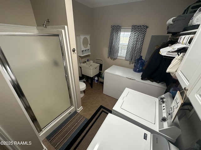 clothes washing area with tile patterned flooring and sink