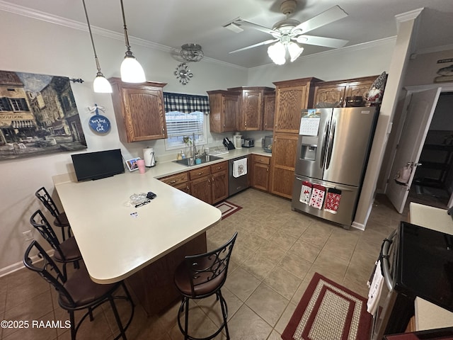 kitchen with a kitchen bar, sink, appliances with stainless steel finishes, kitchen peninsula, and pendant lighting