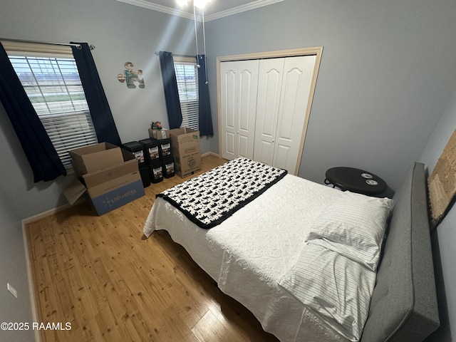 bedroom with hardwood / wood-style floors, ornamental molding, and a closet