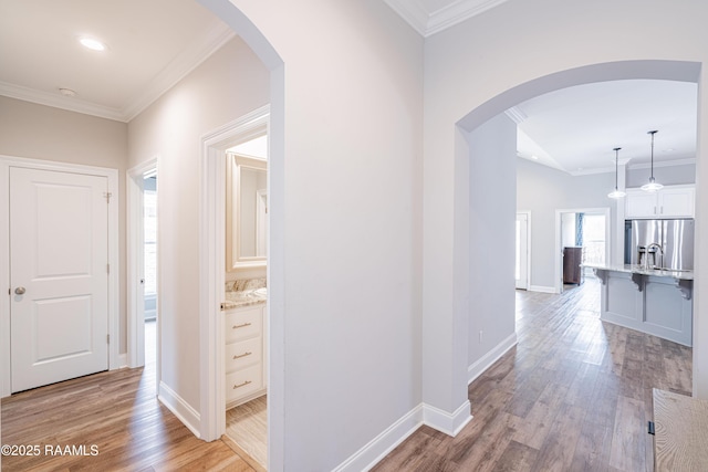 hall featuring ornamental molding and light hardwood / wood-style flooring