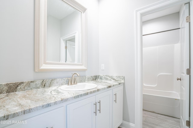 bathroom featuring vanity, wood-type flooring, and  shower combination