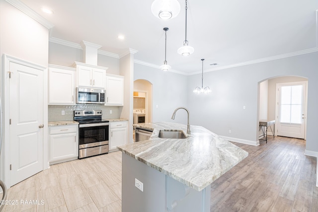 kitchen featuring appliances with stainless steel finishes, sink, an island with sink, and white cabinets