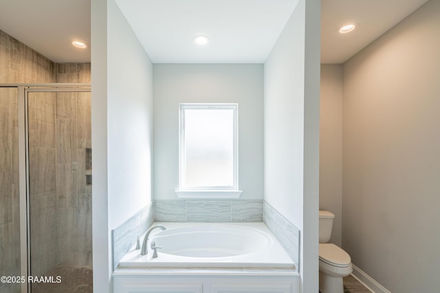 bathroom featuring toilet and plus walk in shower