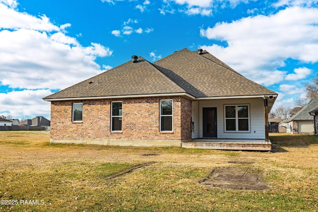 rear view of property featuring a yard and a patio area