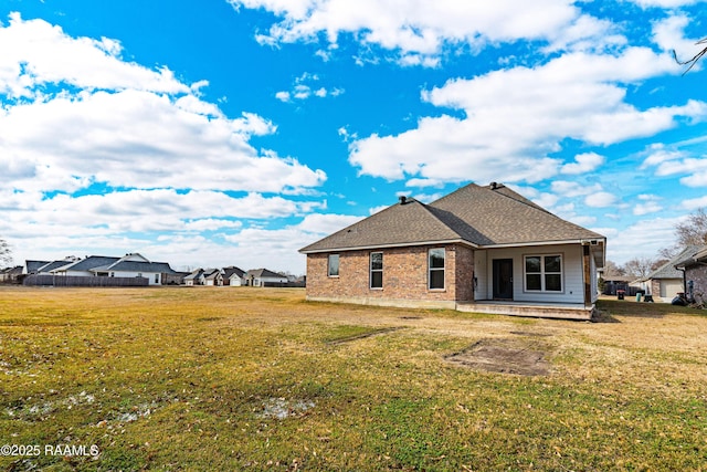 rear view of house with a patio and a lawn