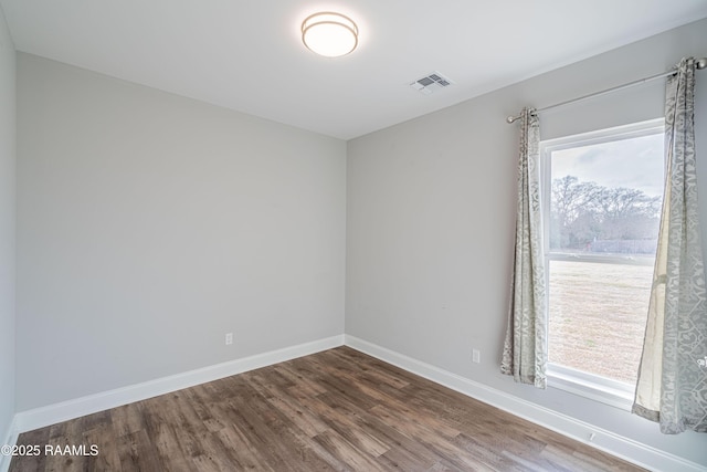 spare room with hardwood / wood-style floors and a wealth of natural light