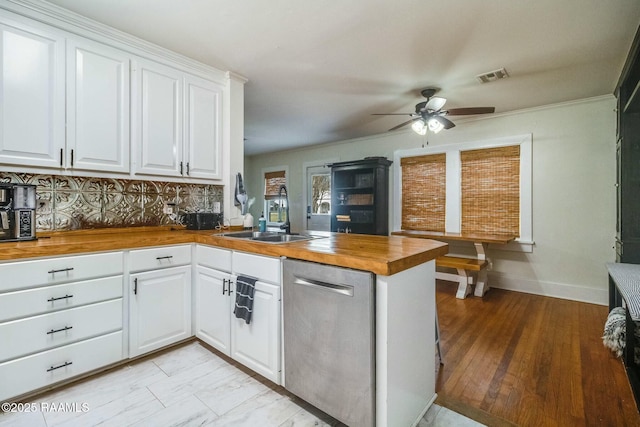 kitchen with white cabinetry, wood counters, and kitchen peninsula