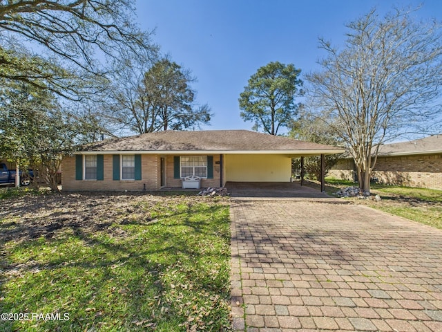 ranch-style home with an attached carport, decorative driveway, and brick siding