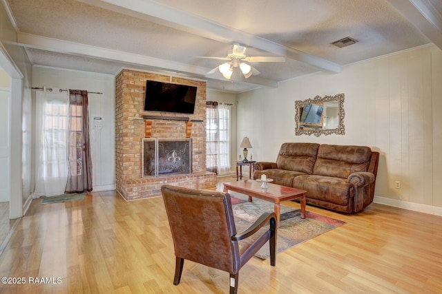 living room featuring a healthy amount of sunlight, wood-type flooring, and beamed ceiling