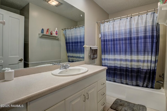 bathroom with tile patterned floors, vanity, shower / bathtub combination with curtain, and a textured ceiling