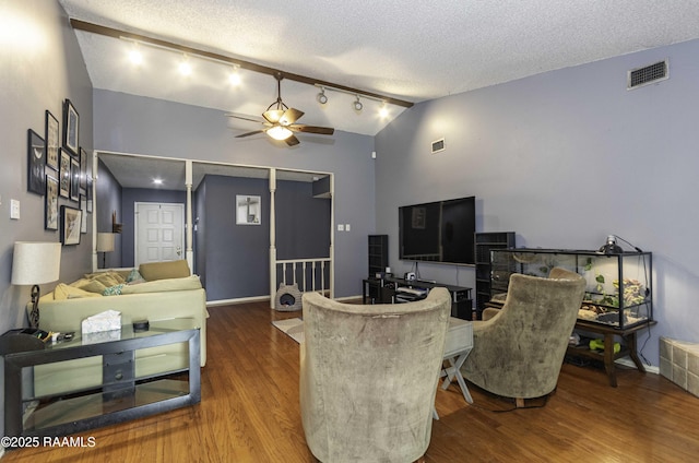 living room with ceiling fan, lofted ceiling, hardwood / wood-style floors, and a textured ceiling