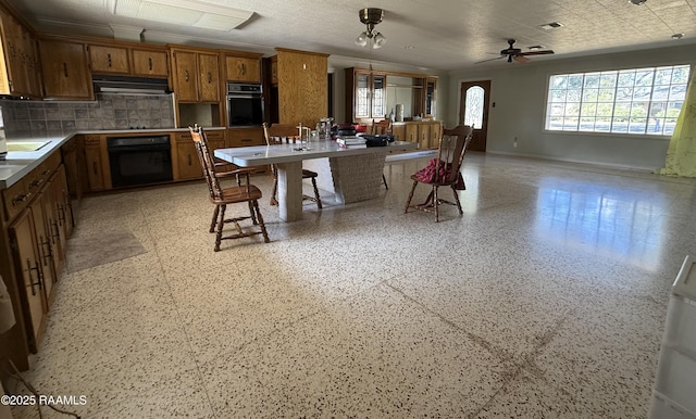 kitchen featuring a breakfast bar area, ceiling fan, backsplash, extractor fan, and black appliances