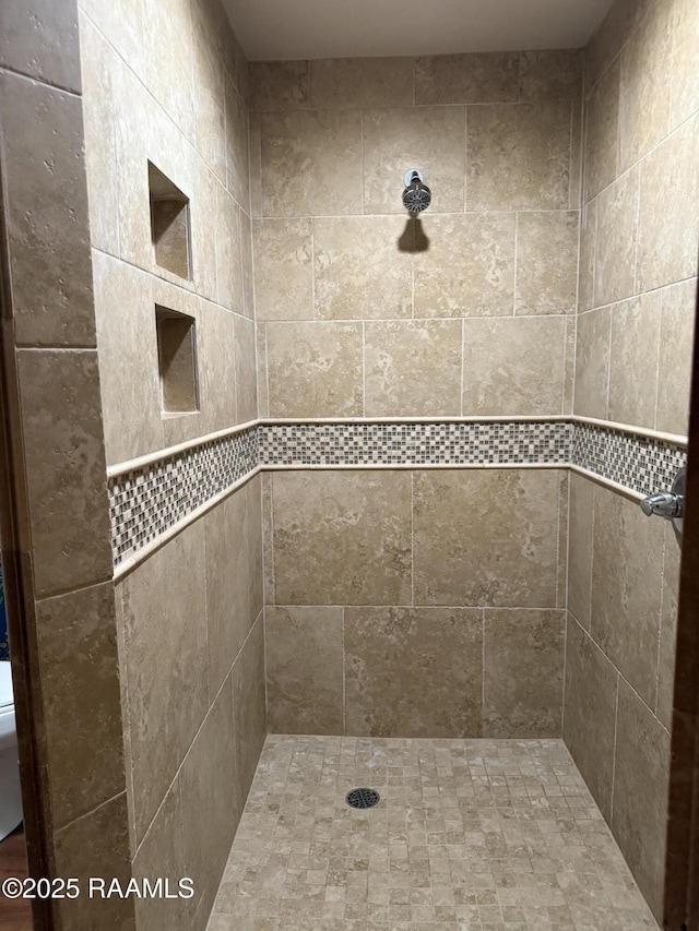 bathroom with tiled shower and toilet