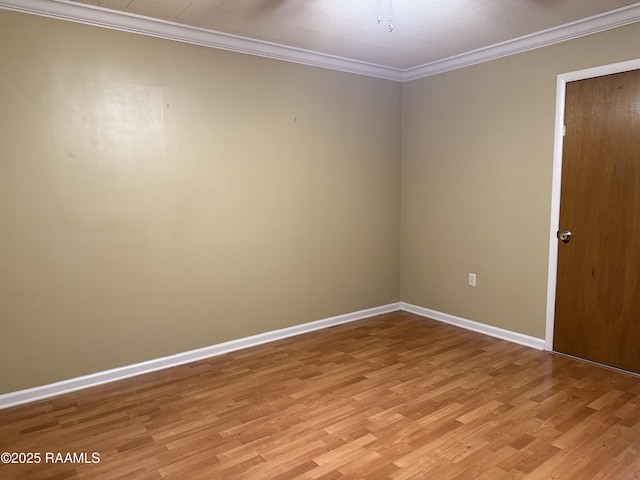 spare room featuring ornamental molding and light hardwood / wood-style flooring