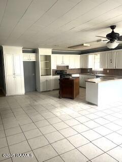 kitchen with white cabinetry, ceiling fan, range, and kitchen peninsula