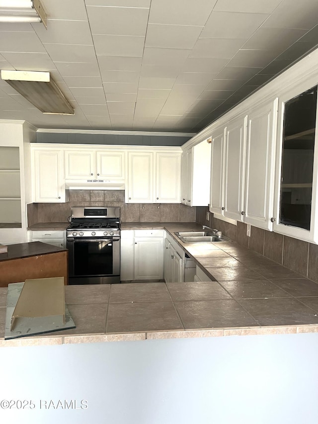 kitchen with white cabinetry, sink, tasteful backsplash, and stainless steel gas range oven