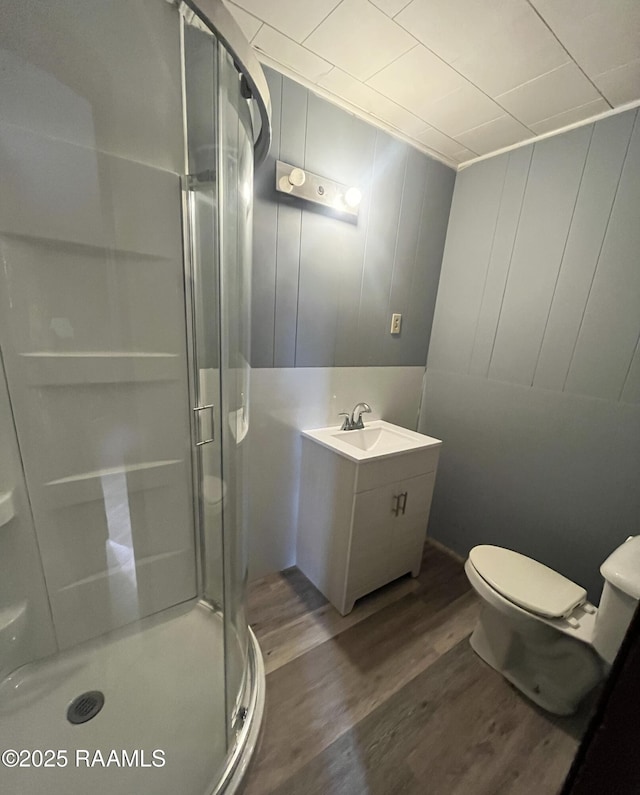 bathroom featuring walk in shower, vanity, toilet, and hardwood / wood-style floors