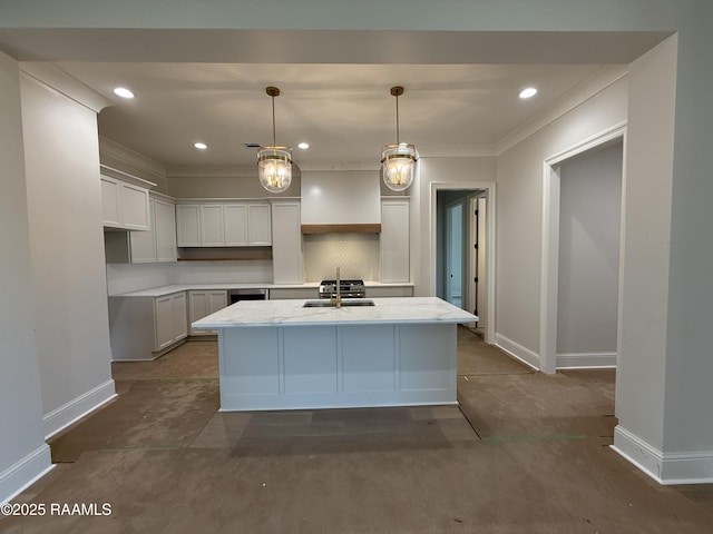 kitchen with sink, white cabinetry, backsplash, an island with sink, and decorative light fixtures