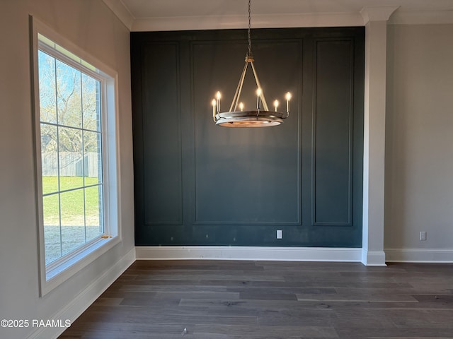 unfurnished dining area featuring crown molding, dark hardwood / wood-style floors, and a chandelier