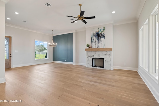 unfurnished living room with light wood-style flooring, a fireplace, visible vents, and ornamental molding