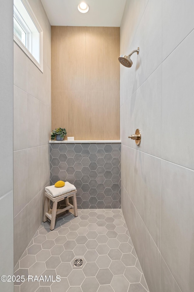 bathroom featuring a tile shower and tile walls