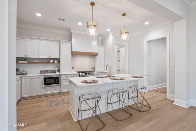 kitchen featuring black microwave, light countertops, and white cabinets