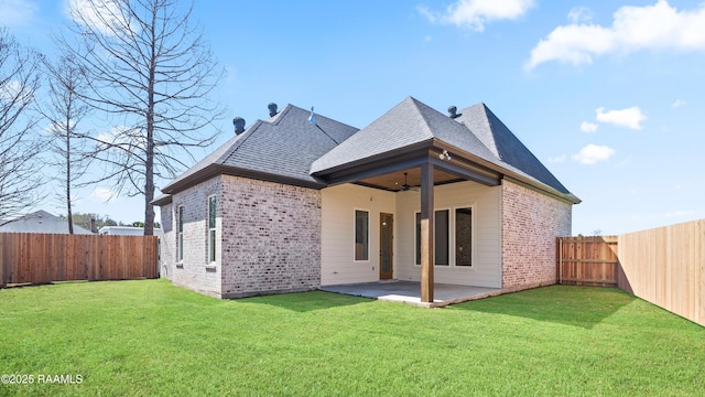 rear view of house featuring a patio, ceiling fan, a fenced backyard, a yard, and brick siding