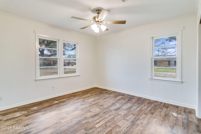 unfurnished room with baseboards, wood finished floors, a ceiling fan, and crown molding