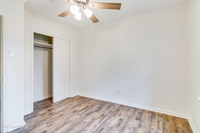 unfurnished bedroom featuring crown molding, a closet, and light wood-style floors