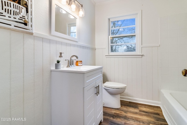 full bathroom with toilet, ornamental molding, wainscoting, vanity, and wood finished floors