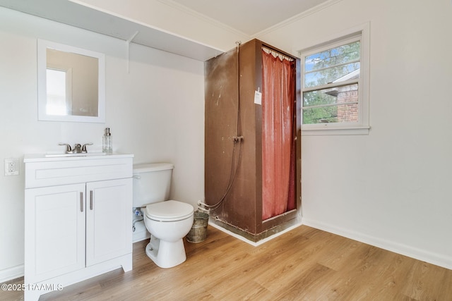 bathroom with ornamental molding, vanity, toilet, and wood finished floors