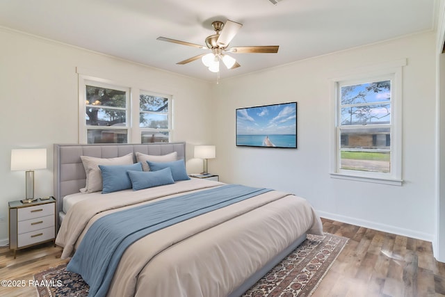 bedroom featuring ornamental molding, baseboards, and wood finished floors