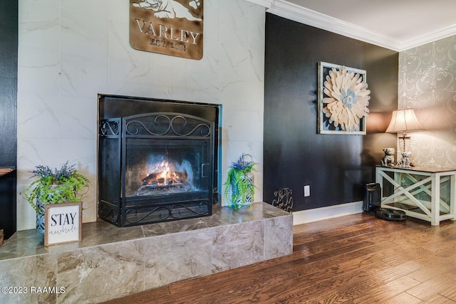 details with a tiled fireplace, ornamental molding, and wood-type flooring