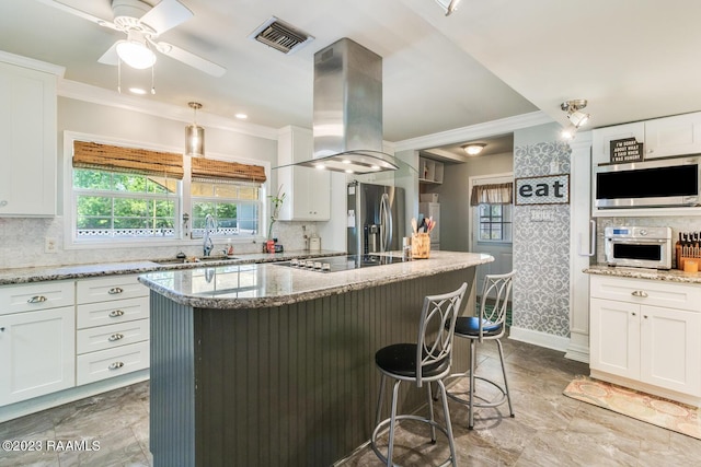 kitchen with sink, stainless steel appliances, light stone counters, white cabinets, and island exhaust hood