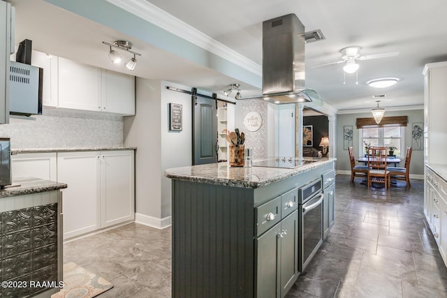 kitchen featuring white cabinetry, stainless steel oven, a barn door, and a center island