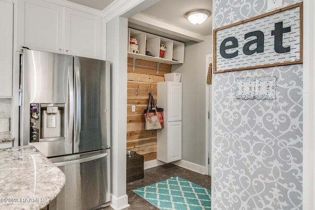 kitchen with light stone counters, white cabinets, and stainless steel refrigerator with ice dispenser