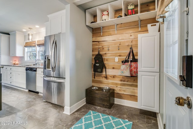 mudroom with sink and wooden walls