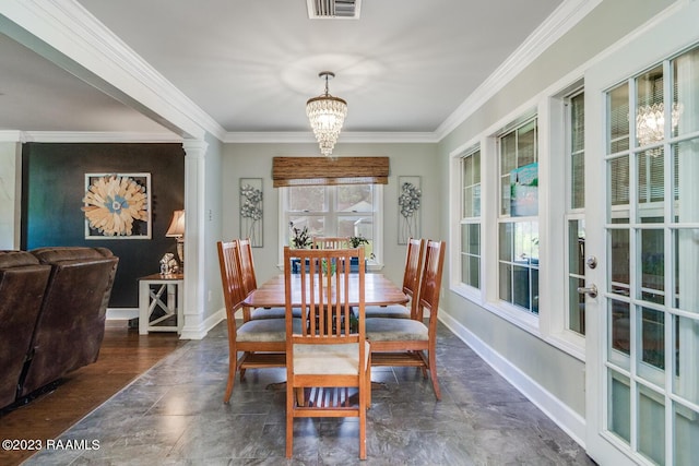 dining space featuring ornamental molding, a chandelier, and ornate columns