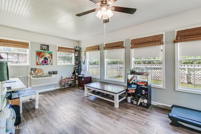 interior space featuring a wall mounted AC, a healthy amount of sunlight, and hardwood / wood-style floors