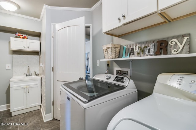 laundry area with sink, ornamental molding, cabinets, and washer and dryer