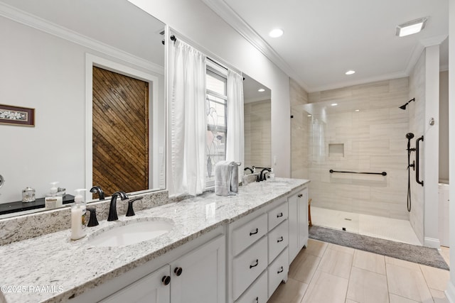 bathroom featuring crown molding, vanity, and a tile shower