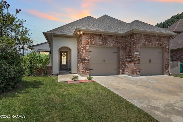 view of front of home featuring a garage and a lawn